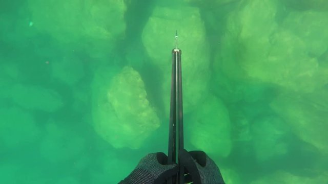 Underwater hunter, fisherman reloads the gun under water.