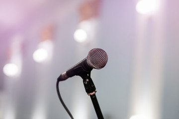 A microphone on stage in a concert hall or american bar (restaurant) during a show.