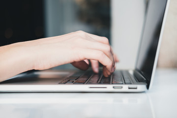 Closeup of woman&rsquo;s hands typing on laptop at cafe outdoors. Freelance concept. Horizontal