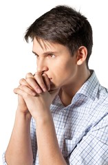 Young man with his arms folded appearing deep in thought