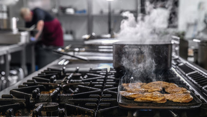 Chef in hotel or restaurant kitchen cooking
