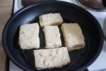 Frying coated cheese Eidam in breadcrumbs