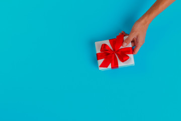 Woman holding gift box on color background