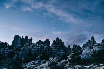 Torcal rocky mountains with the cloudy dark blue sky in the background