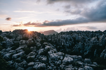 Sun beams graze the summit of torcal rocky mountains at sunset