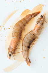 top view of delicious raw shrimps on white surface with watercolor strokes