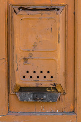 old metal mailbox in orange on the door