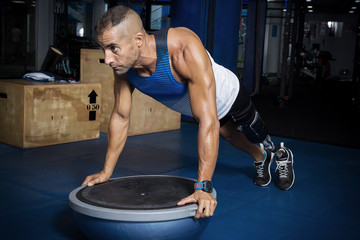 Obraz na płótnie Canvas Athletic man with prosthesis working out