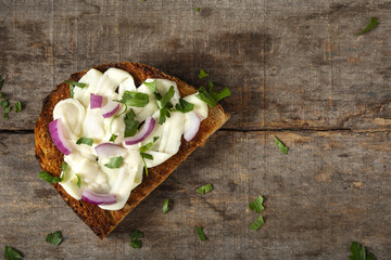 Open sandwich with cream cheese, purple onion and fresh chopped parsley