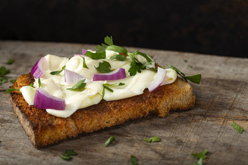 Open sandwich with cream cheese, purple onion and fresh chopped parsley