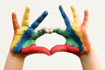 Making a heart with fingers from hands painted with colors