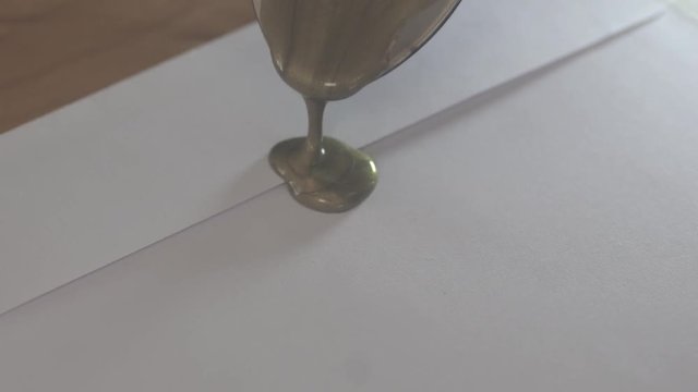 Hang wax on envelope and press stamp it's Sealing wax.
