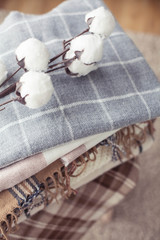 Plaids. Autumn cozy interior. A stack of warm blankets lie on a wooden chair. Autumn. Winter.