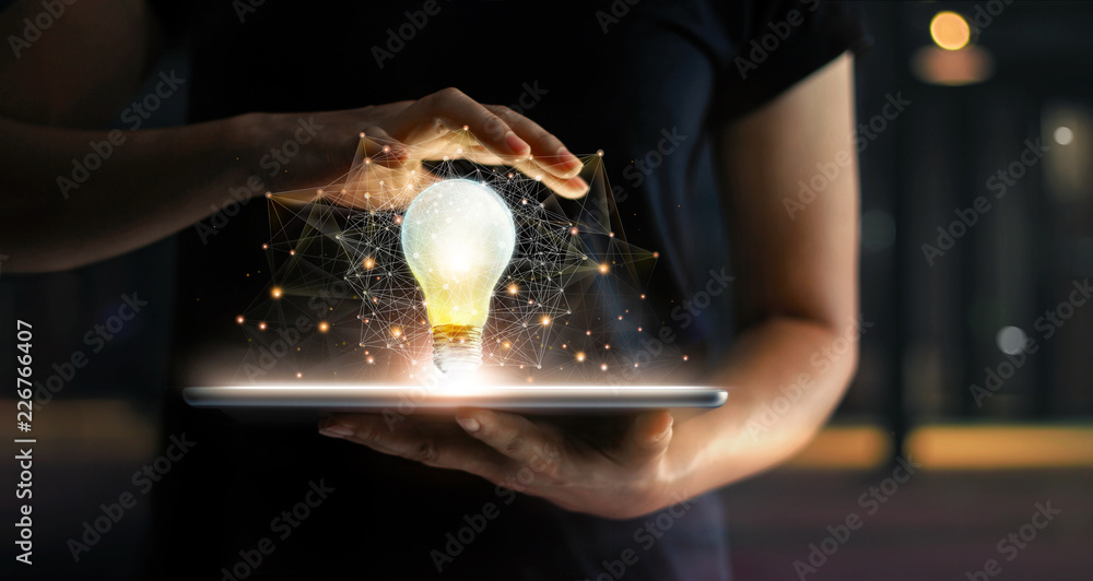 Poster  Abstract business. Human hands holding light bulb glowing on tablet and network connection communication on virtual interface, Innovation and technology concept.