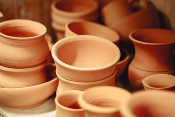 Lots of ceramic pots and jugs on the table.