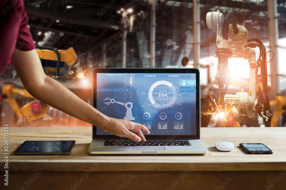 Poster Engineer touching laptop checking and controlling welding robotics automatic arms machine in intelligent factory automotive. Digital manufacturing operation.Industry 4.0