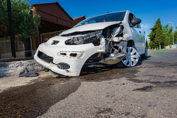 Close-up of crashed car after accident on road in city, sunny day
