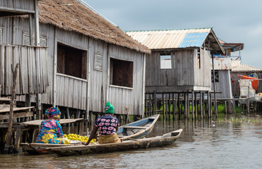 Lake house and boat. Benin lake Nokoué lifestyle African villager living on house in water....