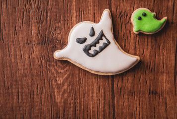 Fresh delicious homemade decorated halloween cookies sweets on dark wooden background, concept of halloween party, copy space(text space), top view, blank for text.