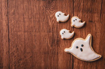 Fresh delicious homemade decorated halloween cookies sweets on dark wooden background, concept of halloween party, copy space(text space), top view, blank for text.