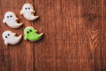 Fresh delicious homemade decorated halloween cookies sweets on dark wooden background, concept of halloween party, copy space(text space), top view, blank for text.