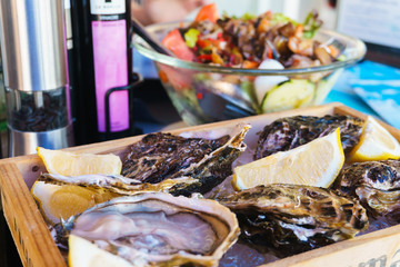 Fresh oysters on ice with lemon wedges.