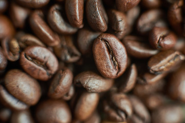 Roasted coffee beans on rustic wooden background. Food ingredients, top view, space for text