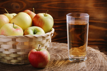 apple juice with apple basket on dark background with glass of juice