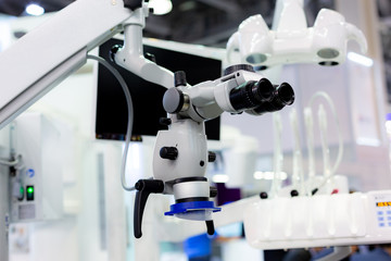 Dental microscope on the background of modern dentistry. Medical equipment. Dental operating microscope with rotary double binocular.