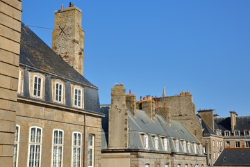 Fototapeta na wymiar Traditional house facades with chimneys and roofs, located inside the walled city and viewed from the ramparts, Saint Malo, Brittany, France
