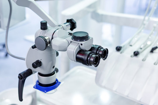 Dental microscope on the background of modern dentistry. Medical equipment. Dental operating microscope with rotary double binocular.