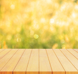 Naklejka na ściany i meble Empty wooden deck table with foliage bokeh background. Ready for product display montage.