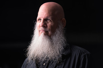 Portrait Of Bald Man With Gray Beard Thinking Outdoors At Night