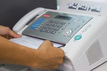 hand man are using a fax machine in the office Business concept office life 
