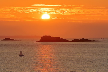 Colorful sunset viewed from the ramparts of the walled city of Saint Malo, Brittany, France, with Harbour Island in the background