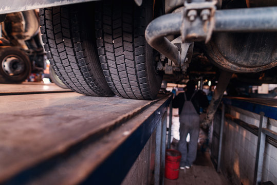 Close Up Of Truck Tires. Repairing Old Truck In Car Workshop.