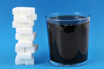 Verre de soda et pile de sucres 