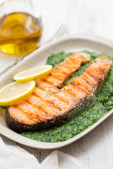 grilled salmon with lemon and spinach on dish