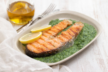 grilled salmon with lemon and spinach on dish