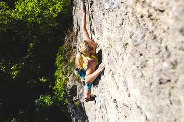Fototapeta premium The woman climbs the rock.
