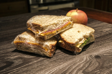 sandwich halves in plastic wrap with apple