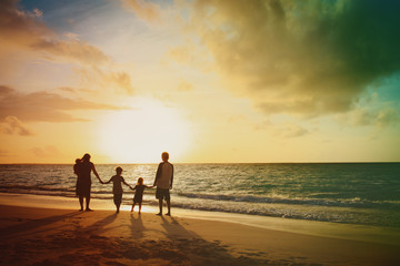 happy family with kids walking at sunset tropical beach