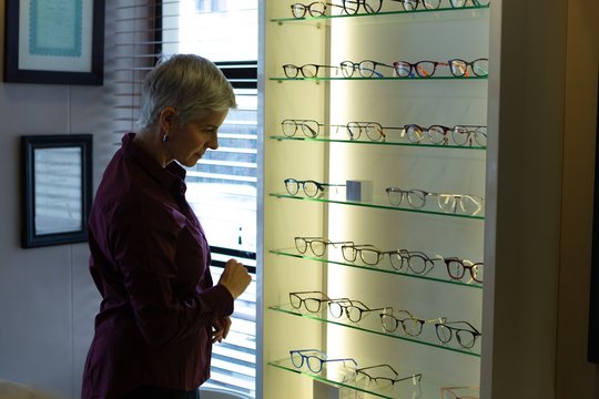 Senior woman selecting frame in clinic