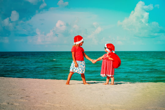 happy kids- cute little girls- celebrating christmas on beach