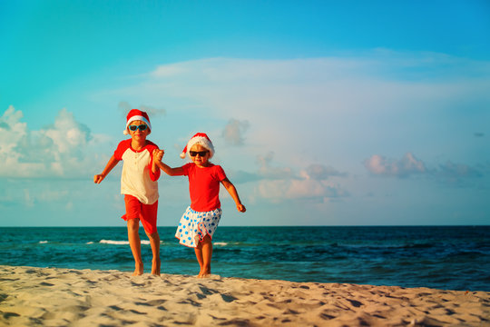 happy kids-little boy and girl- celebrating christmas on beach