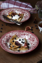 Homemade crepes with fresh figs blueberries and sour cream
