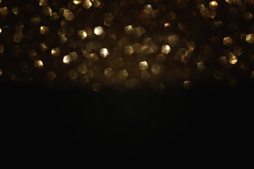 glitter vintage lights background. black and gold. de-focused.