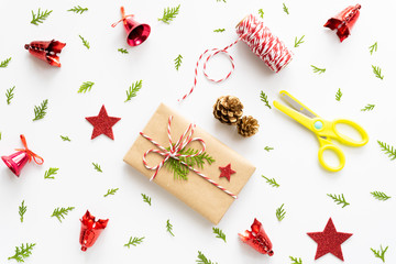 Christmas background concept. Top view of Christmas gift box with tag message, red star and pine cones on white background.