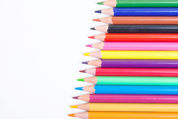 Colorful wooden pencils on isolated white background. A drawing tool. Objects for creativity. Colored pencils on a light background in a diagonal line.