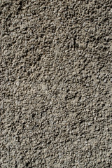 the wall of the house is white decorated with lots of small stones and cement